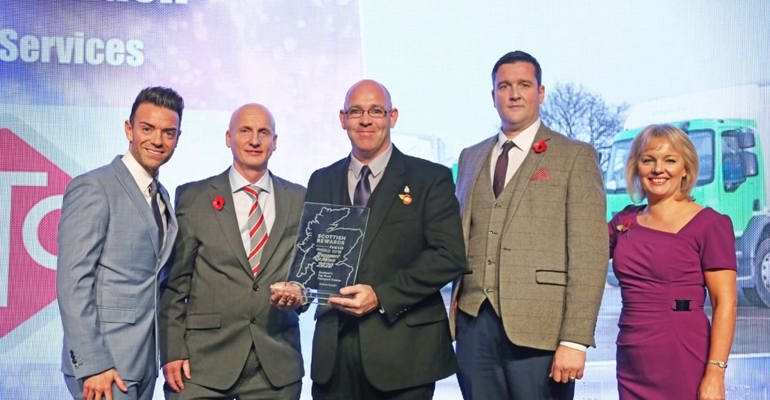 GTG Trainee winning a prize on stage with the speakers