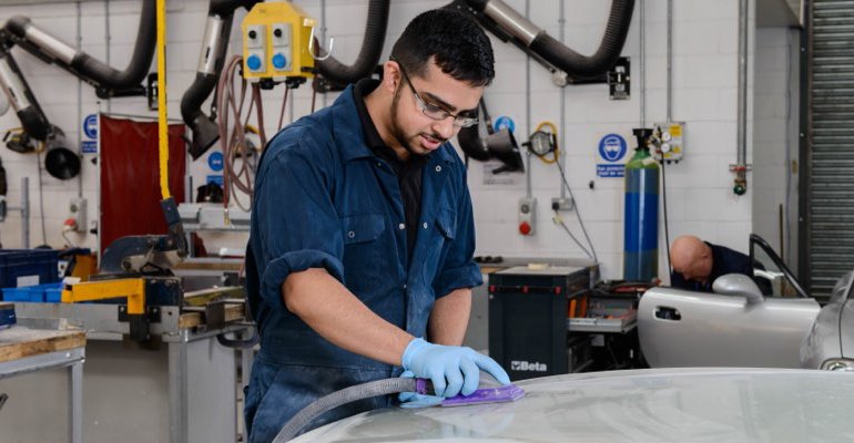 Apprentice sanding car bonnet