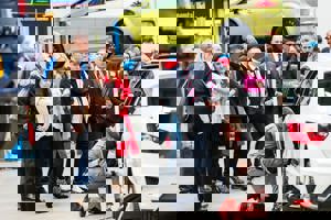 A group at a GTG open day watching and apprentice work on a car in the workshop