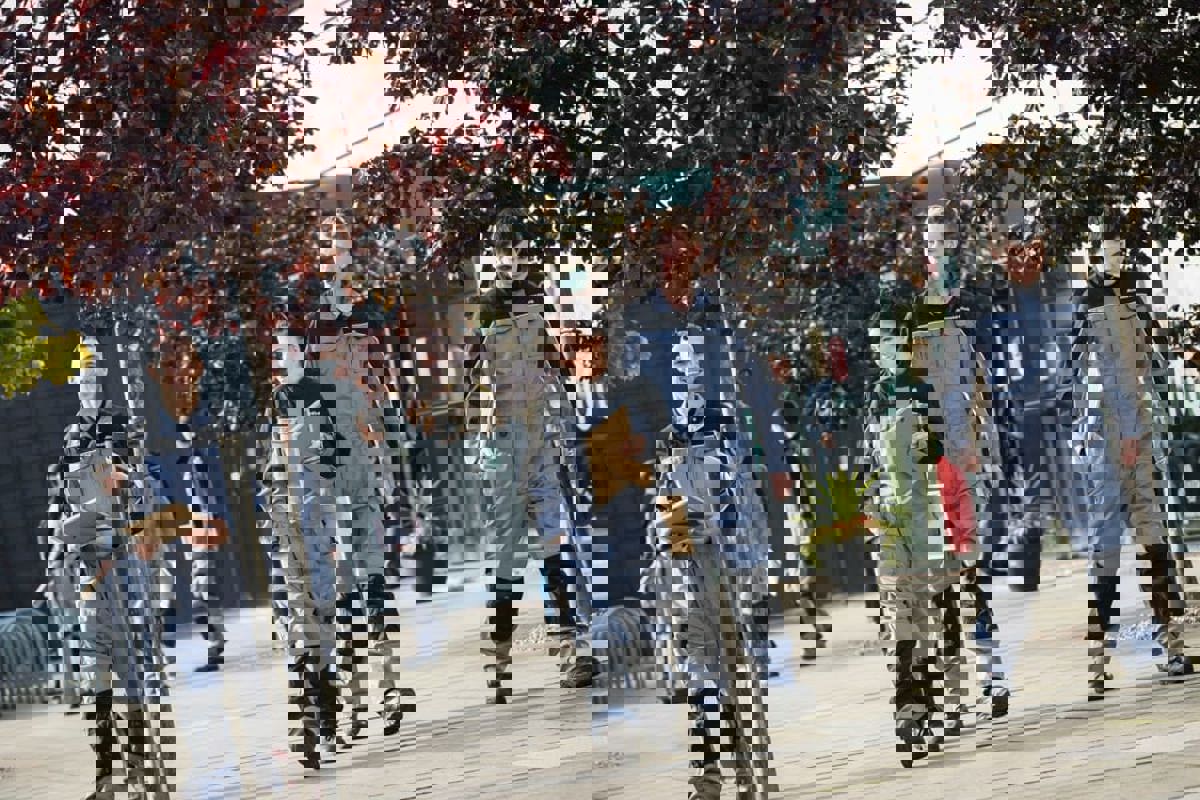 Four apprentices walking in front of GTG building with their certificates