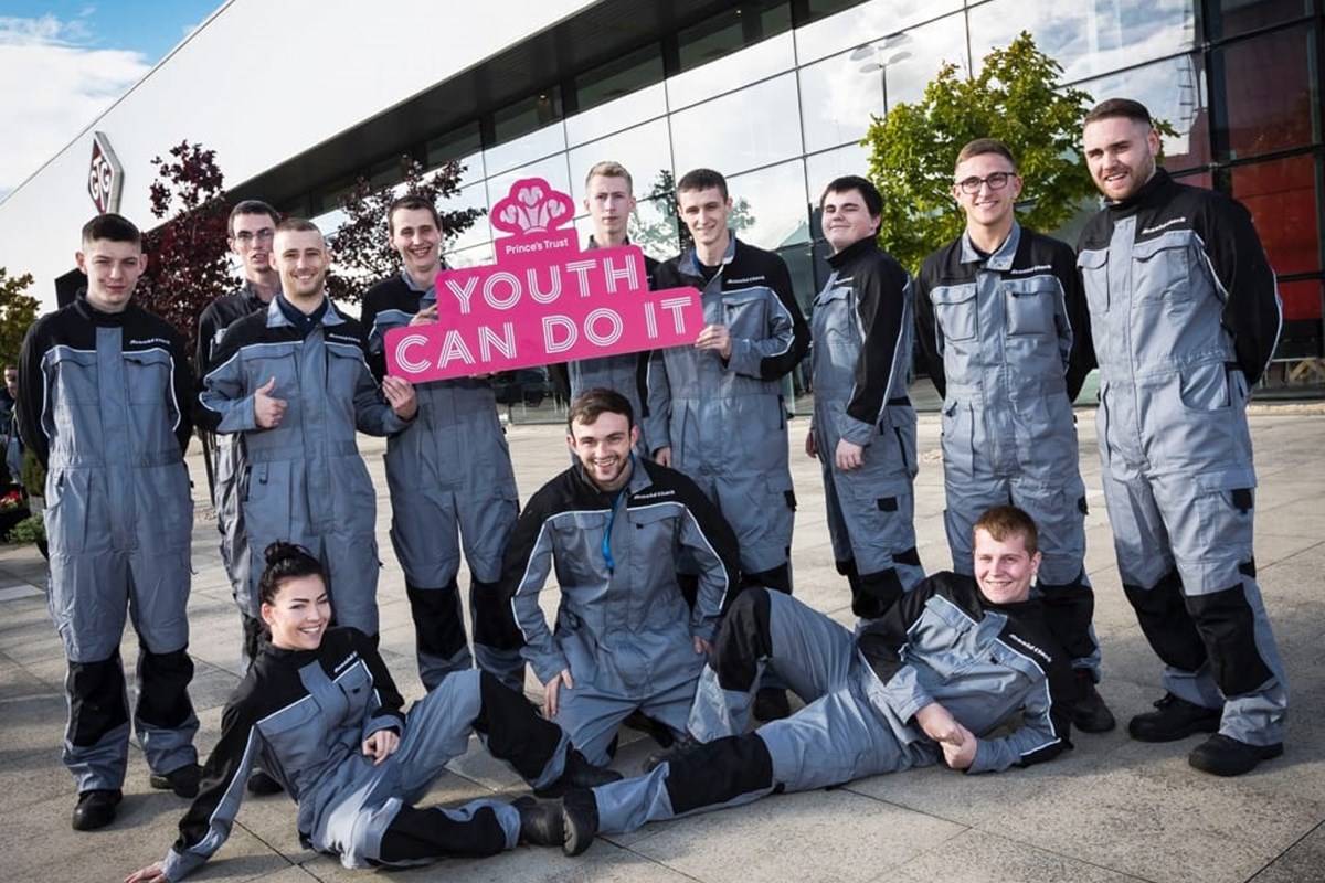 12 GTG Princes Trust apprentices holding a pink 'Youth Can Do It' sign